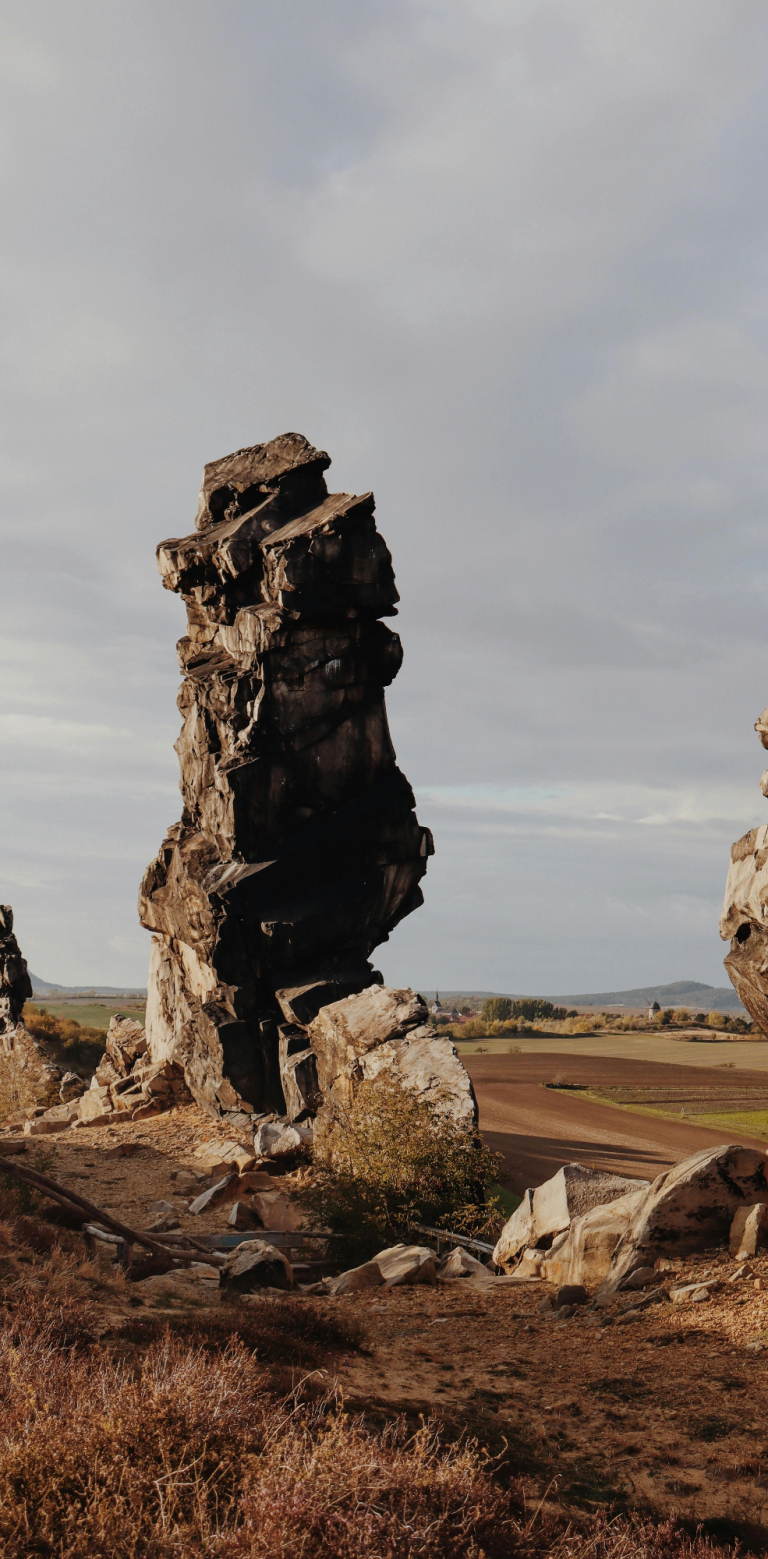 Ausläufer der Teufelsmauer Felsformationen in einer offenen Landschaft unter einem bewölkten Himmel.